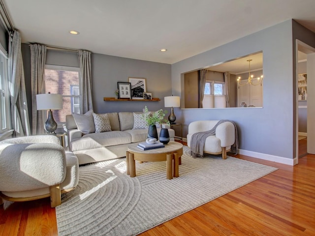 living area with a chandelier, recessed lighting, baseboards, and wood finished floors