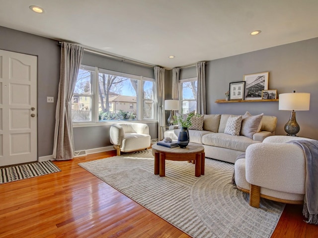 living area featuring visible vents, baseboards, wood finished floors, and recessed lighting