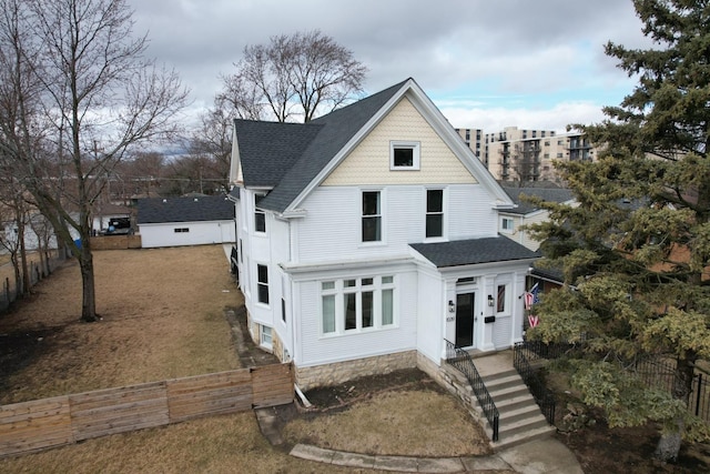 view of front of property with a shingled roof and fence private yard