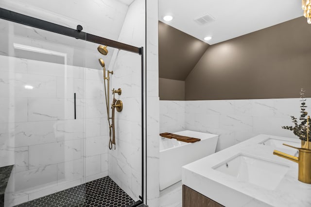 full bathroom featuring a marble finish shower, lofted ceiling, marble finish floor, a freestanding bath, and a sink