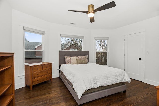 bedroom featuring a ceiling fan, baseboards, visible vents, and dark wood-type flooring