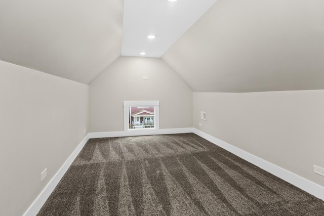 additional living space featuring dark carpet, baseboards, vaulted ceiling, and recessed lighting