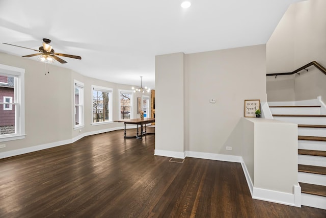 entryway with baseboards, visible vents, stairway, wood finished floors, and ceiling fan with notable chandelier