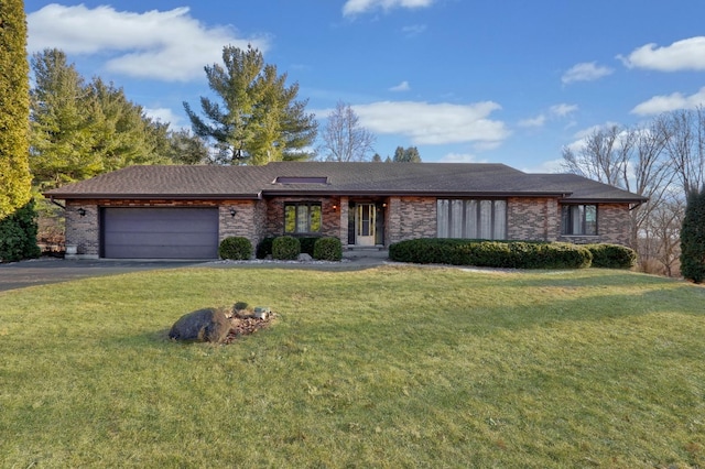 view of front facade with a garage, driveway, a front lawn, and brick siding