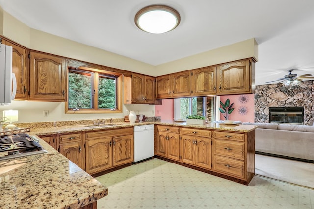 kitchen featuring light floors, open floor plan, a sink, dishwasher, and a peninsula