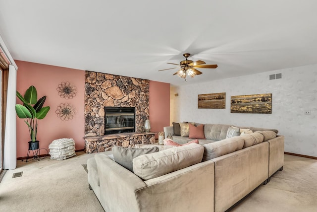 living area featuring light carpet, a fireplace, and visible vents