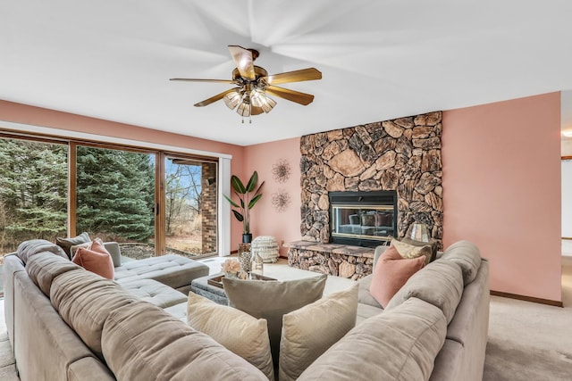 living area with light carpet, ceiling fan, and a fireplace