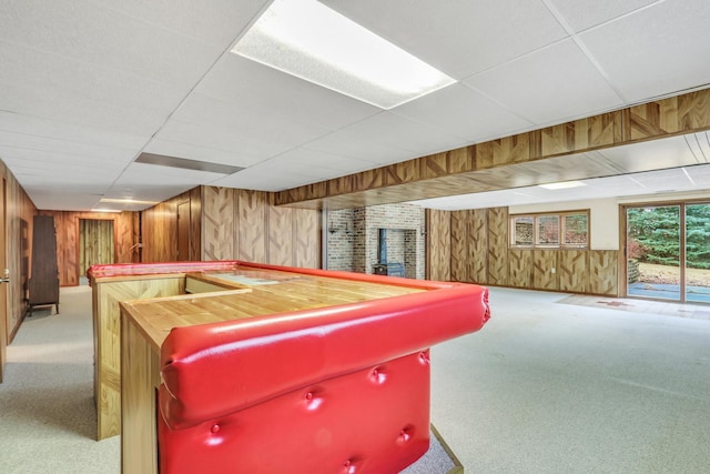 playroom featuring carpet floors, wood walls, a dry bar, and a drop ceiling