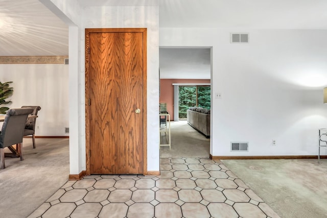 interior space with light colored carpet, visible vents, and baseboards