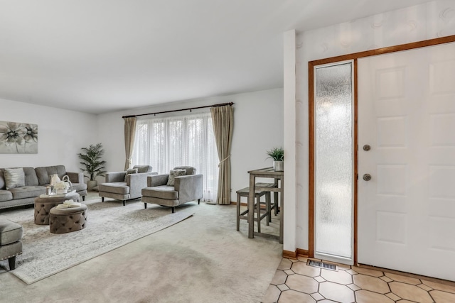 living area featuring light colored carpet, visible vents, and light tile patterned floors