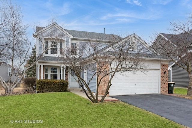 traditional-style house with an attached garage, a front yard, aphalt driveway, and brick siding