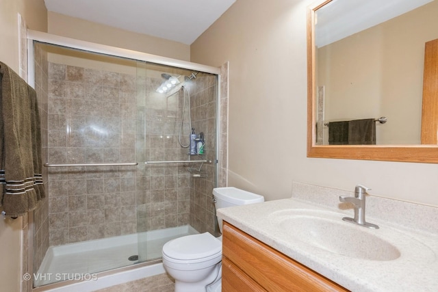 full bathroom with a stall shower, vanity, and toilet