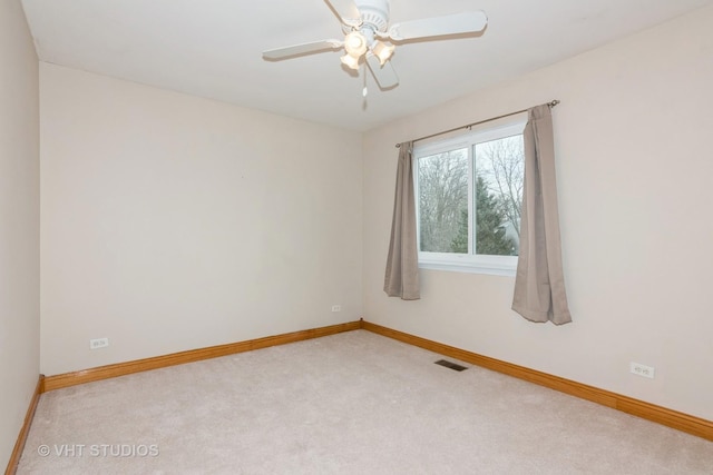 spare room with ceiling fan, carpet, visible vents, and baseboards