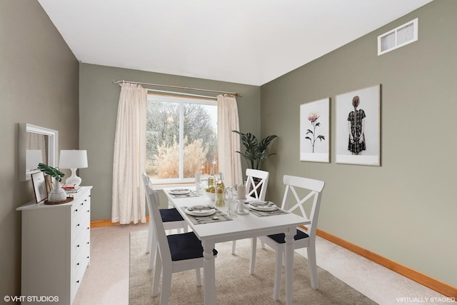 dining room featuring visible vents, light carpet, and baseboards