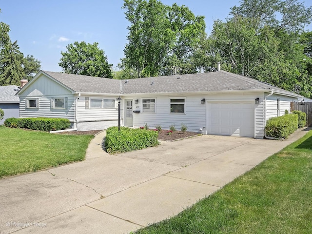 ranch-style home with concrete driveway, roof with shingles, an attached garage, and a front yard