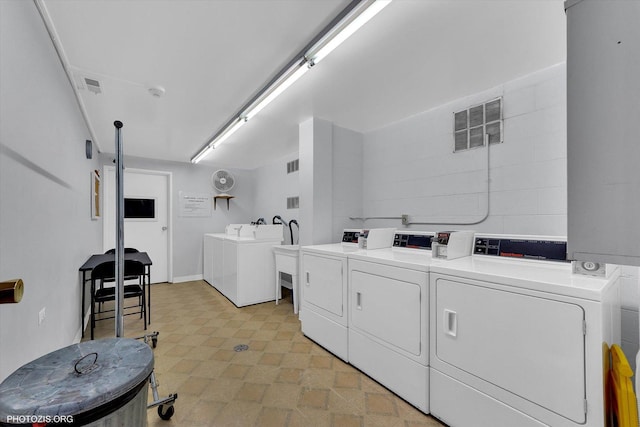 common laundry area with visible vents, light floors, and washing machine and dryer