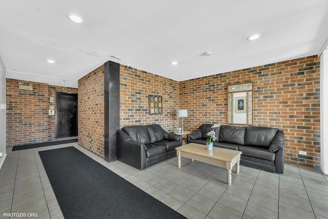 living area featuring light tile patterned flooring, visible vents, recessed lighting, and brick wall