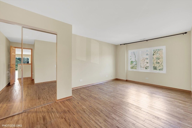 empty room with baseboards and light wood-style floors