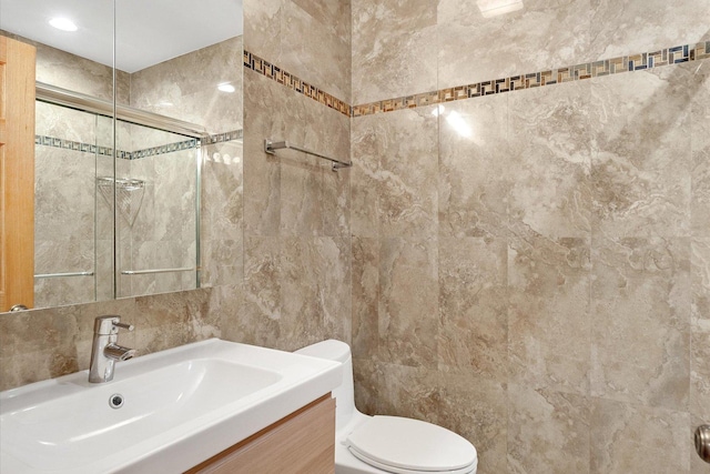 full bath with a shower with shower door, toilet, tile walls, decorative backsplash, and vanity