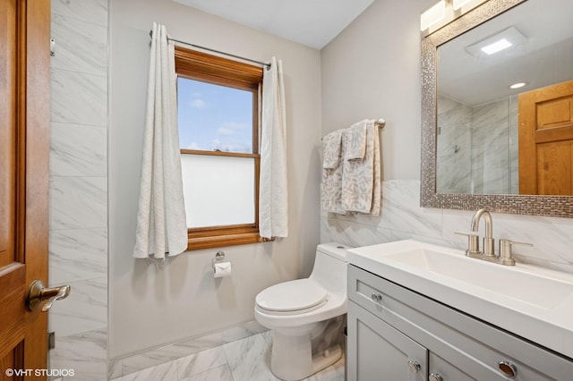 full bathroom featuring marble finish floor, tile walls, toilet, a tile shower, and vanity