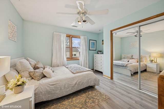 bedroom featuring visible vents, a closet, a ceiling fan, and wood finished floors