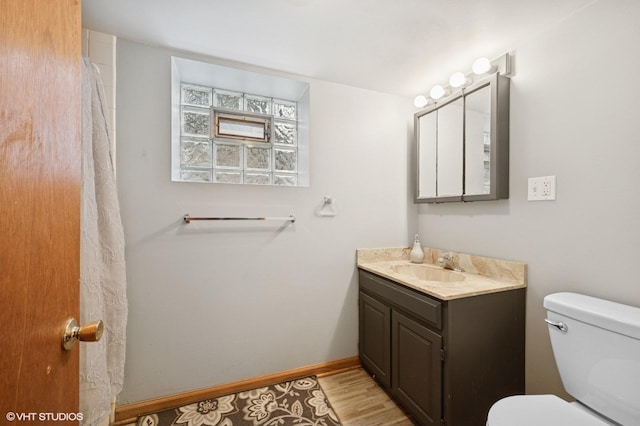 full bath with vanity, wood finished floors, toilet, and baseboards