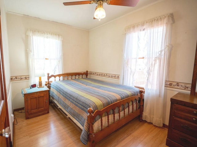 bedroom featuring light wood-style flooring, ceiling fan, and ornamental molding