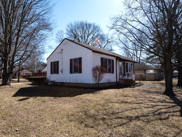 view of side of home featuring cooling unit and a yard