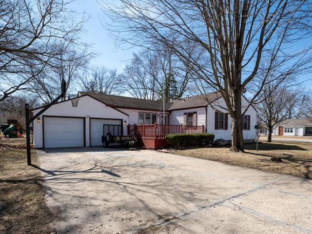 view of front of house with a deck, concrete driveway, and an attached garage