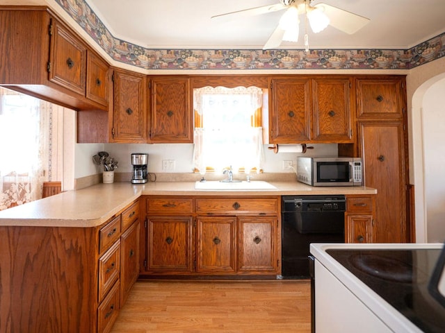 kitchen with electric range, brown cabinets, a sink, stainless steel microwave, and dishwasher