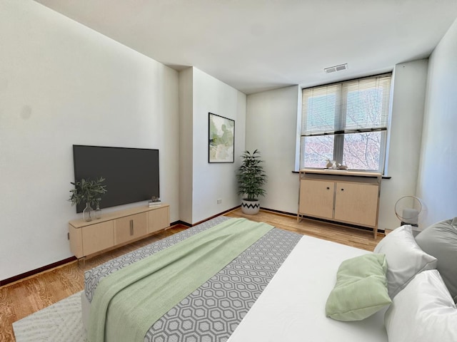 bedroom with visible vents, light wood-style flooring, and baseboards