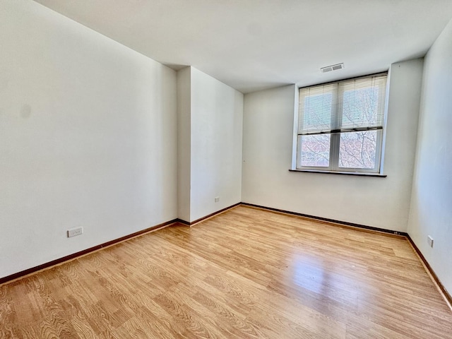 unfurnished room with visible vents, baseboards, and wood finished floors