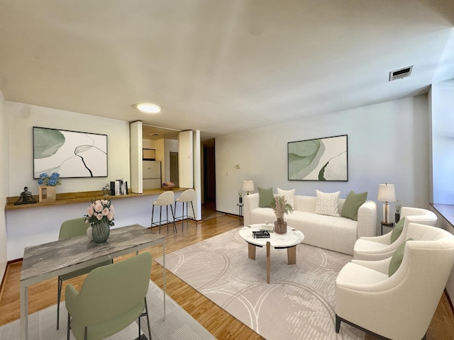 living room featuring visible vents and wood finished floors