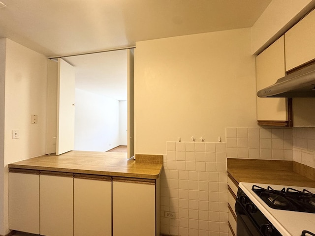 kitchen featuring tile walls, range with gas cooktop, white cabinetry, and under cabinet range hood