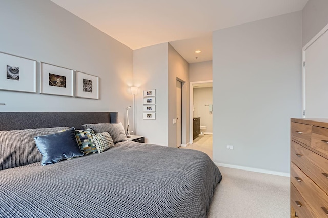 bedroom featuring light carpet, ensuite bath, baseboards, and recessed lighting