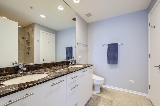 bathroom with toilet, a sink, visible vents, and a tile shower