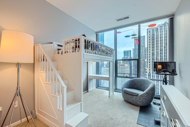 stairway featuring carpet, floor to ceiling windows, and visible vents