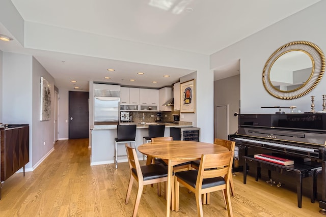 dining space with recessed lighting, light wood-style flooring, and baseboards