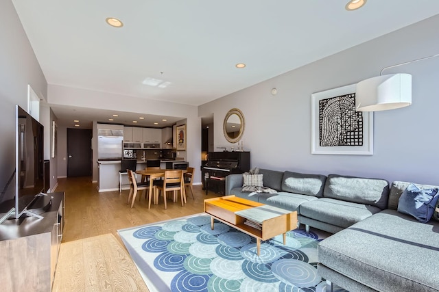 living area with light wood-type flooring, baseboards, and recessed lighting