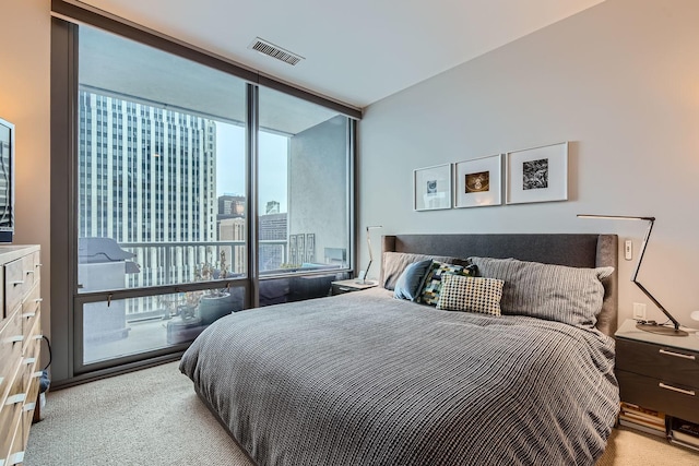 bedroom with expansive windows, carpet, visible vents, and access to exterior