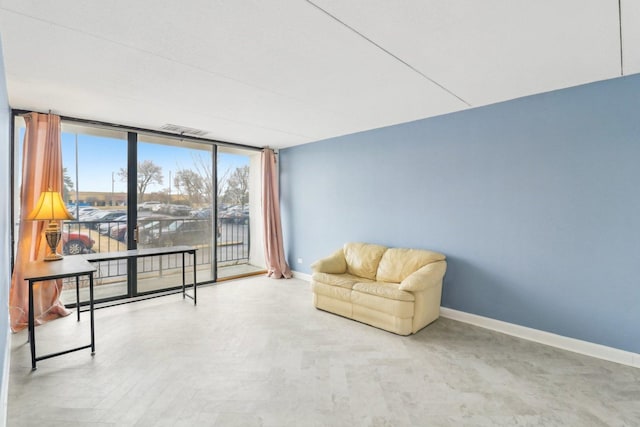 sitting room featuring visible vents, baseboards, and floor to ceiling windows