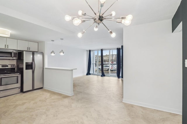 kitchen featuring stainless steel appliances, baseboards, open floor plan, and expansive windows