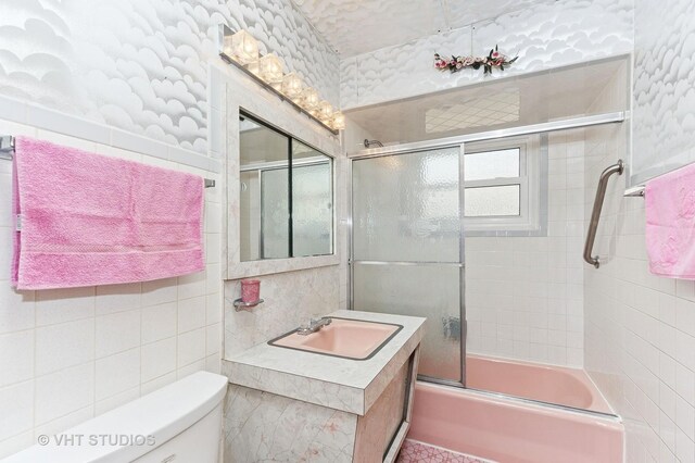6938 W Jonquil Ter, Niles, IL 60714 - bathroom featuring tile walls, toilet, bath / shower combo with glass door, and vanity