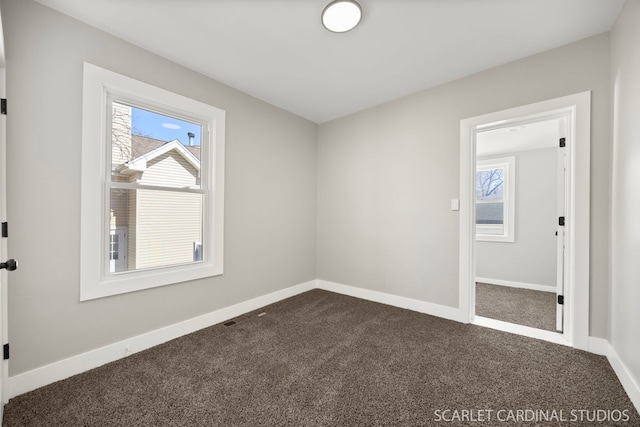 empty room featuring baseboards and carpet