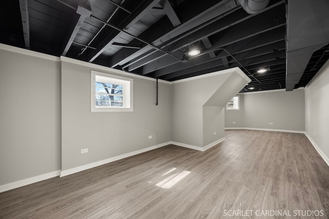 basement featuring wood finished floors and baseboards