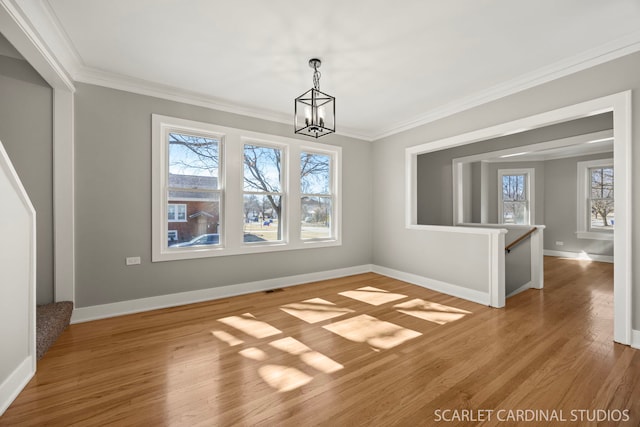 unfurnished dining area with crown molding, wood finished floors, and a healthy amount of sunlight