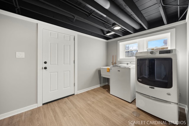 laundry room with light wood finished floors, laundry area, washer and clothes dryer, and baseboards