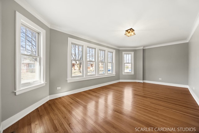 unfurnished room with crown molding, wood finished floors, and baseboards