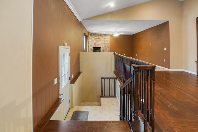 stairway with ceiling fan, baseboards, lofted ceiling, a fireplace, and tile patterned floors