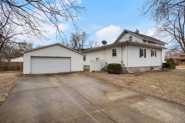 exterior space with an outbuilding, fence, a garage, and a chimney